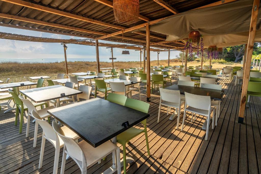 un restaurant avec des tables et des chaises sur une terrasse dans l'établissement Camping Domaine d'Anghione, à Castellare-di-Casinca