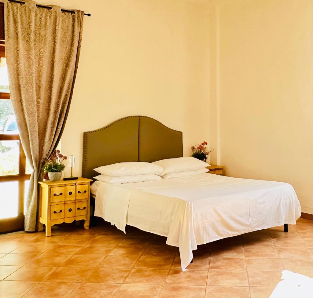 une chambre avec un grand lit avec des draps blancs dans l'établissement Casa Paloma Private Villa, à Cicerale