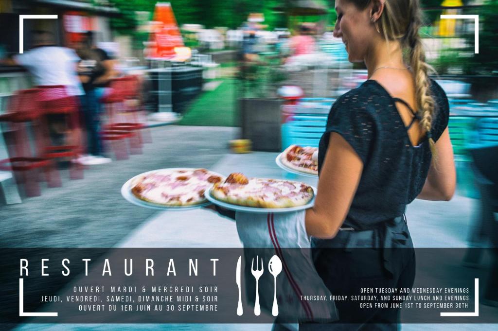 une affiche d'une femme tenant deux assiettes de pizzas dans l'établissement Les Eaux Chaudes, à Digne-Les-Bains