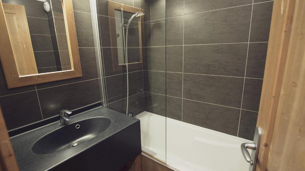 une salle de bain avec un lavabo et une douche dans l'établissement Résidence Les Grandes Feignes, à La Bresse