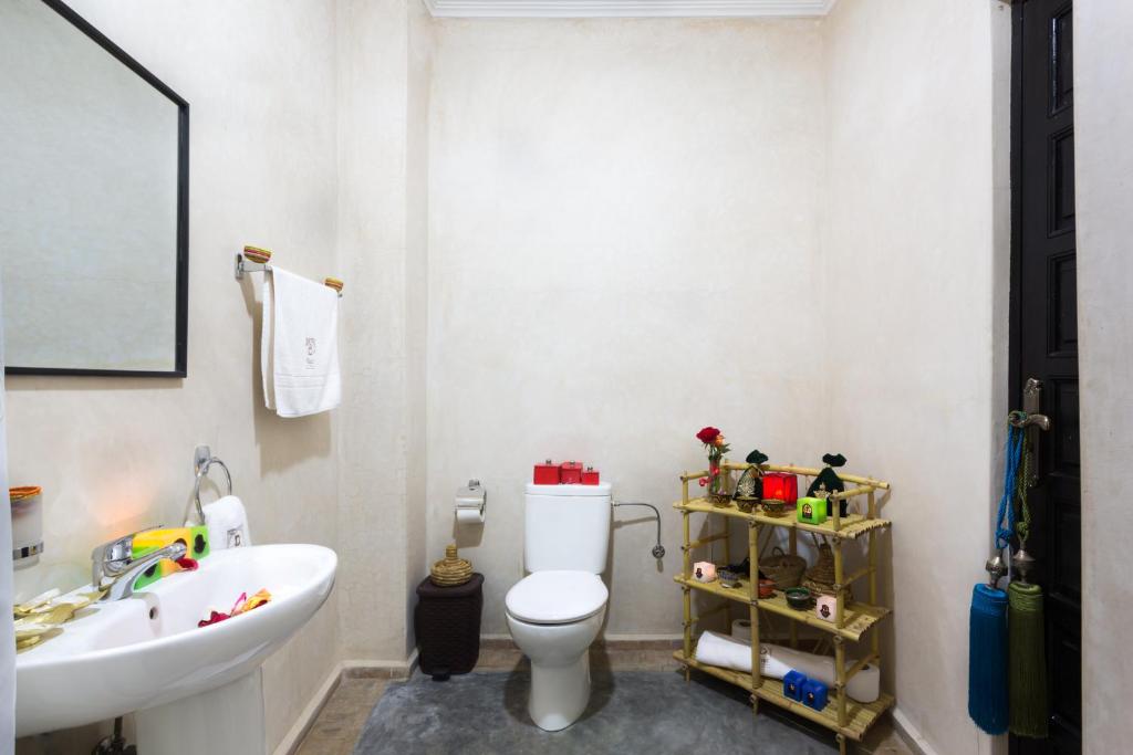 une salle de bain avec des toilettes blanches et un lavabo dans l'établissement Riad Dar Benbrahim, à Marrakech