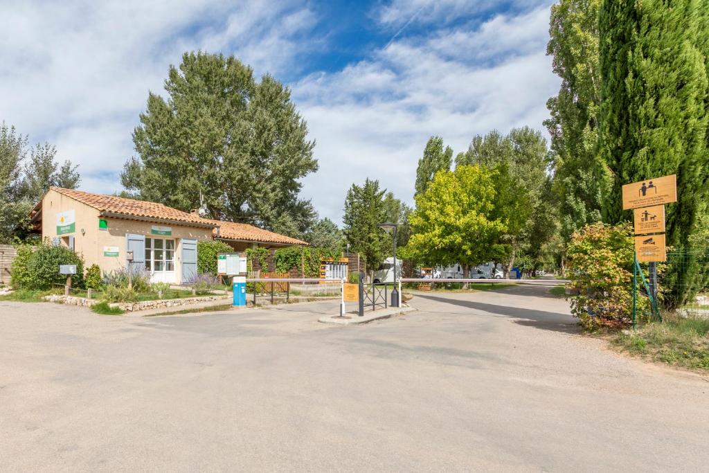 une route avec un panneau devant une maison dans l'établissement Camping Bel Air Village Les Prés du Verdon, à Quinson
