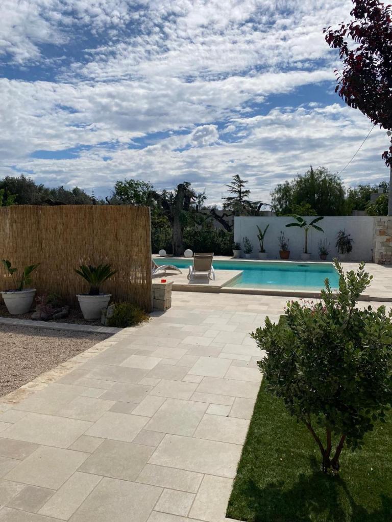 une cour avec une piscine et une clôture dans l'établissement Villa Leone Holiday House, à Latiano