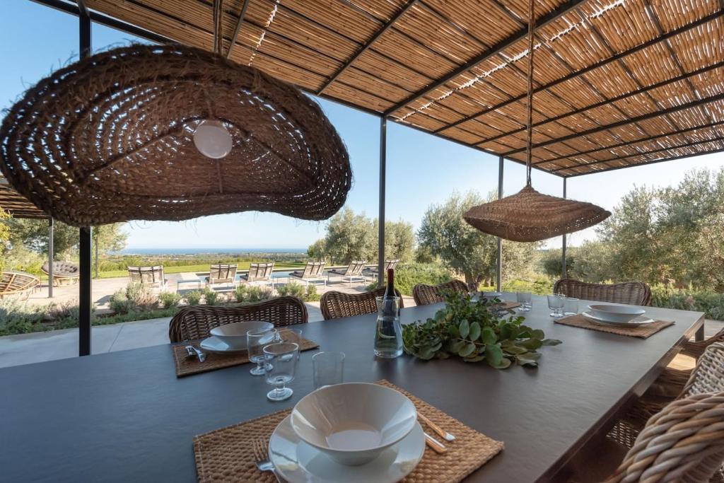 - une table à manger avec vue sur l'océan dans l'établissement Villa Vogue - IsulaTravel, à Avola