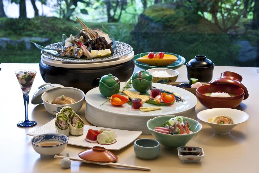 une table avec des assiettes et des bols de nourriture dans l'établissement TAKITEI Riverside Onsen ーA Hidden Ryokan in Kanazawaー, à Kanazawa