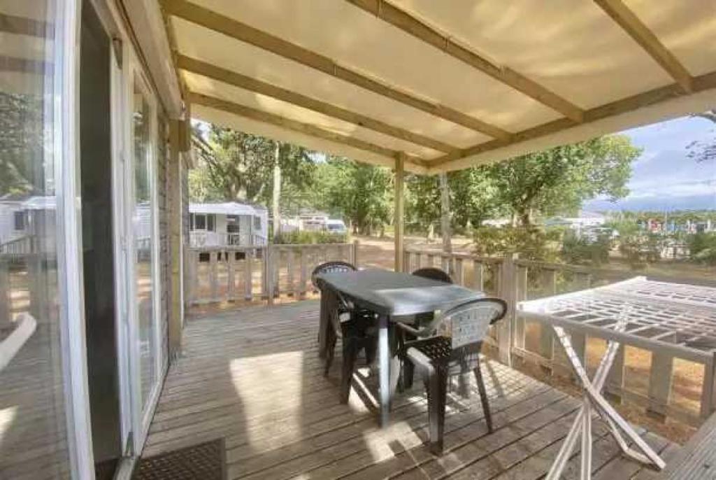 un patio avec une table et des chaises sur une terrasse dans l'établissement Camping 3 étoiles - Piscine - eebebg, à Guéméné-Penfao