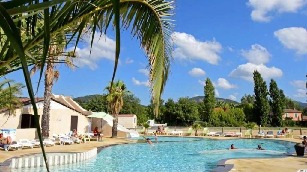 une grande piscine avec des gens dans un complexe hôtelier dans l'établissement Camping 4 étoiles - Parc aquatique - eece0c, à Grimaud