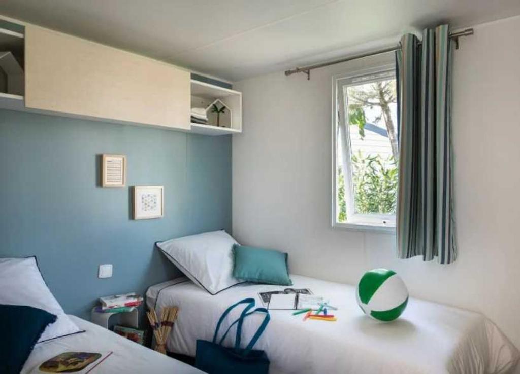 une chambre avec deux lits et une fenêtre dans l'établissement Camping - Parc aquatique - ccag00b, à Saint-Jean-dʼOrbetiers