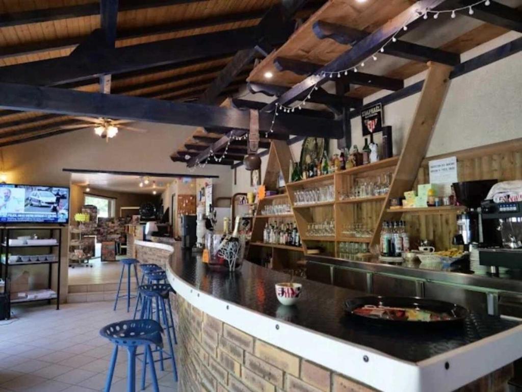 un bar dans un restaurant avec un comptoir et des tabourets dans l'établissement Camping 4 étoiles - Piscine - ccaaagh, à Carennac