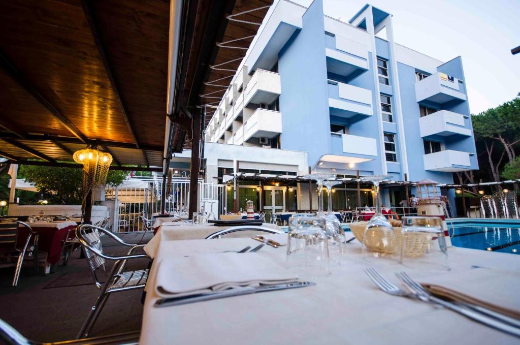 une table avec plaques et argenterie devant un bâtiment dans l'établissement Grand Hotel Helios, à Tarquinia