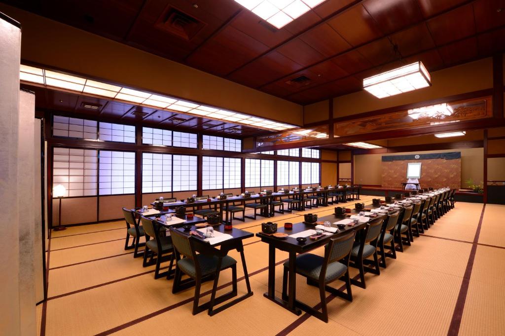 une grande chambre avec des tables et des chaises. dans l'établissement Senkeien Tsukioka Hotel, à Kaminoyama 37 autres photos