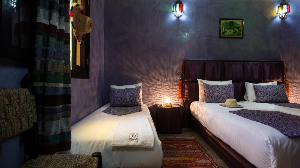 une chambre avec deux lits et une lampe sur une table dans l'établissement Riad Dar Benbrahim, à Marrakech