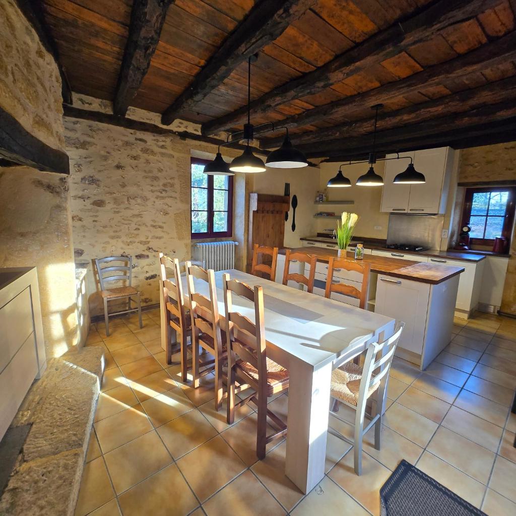 une cuisine et une salle à manger avec une table et des chaises dans l'établissement Gîte Les Combes Montignac Lascaux, à Montignac