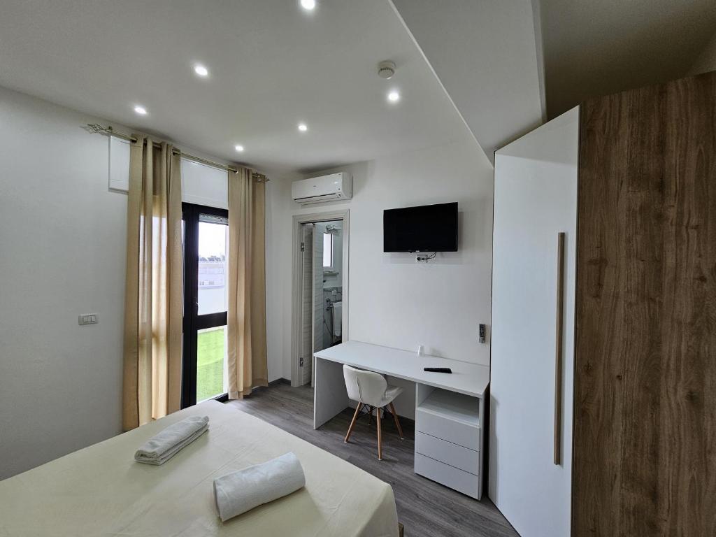 une chambre avec un lit, un bureau et une télévision dans l'établissement Hotel Baia del Cigno, à Torre San Giovanni 149 autres photos