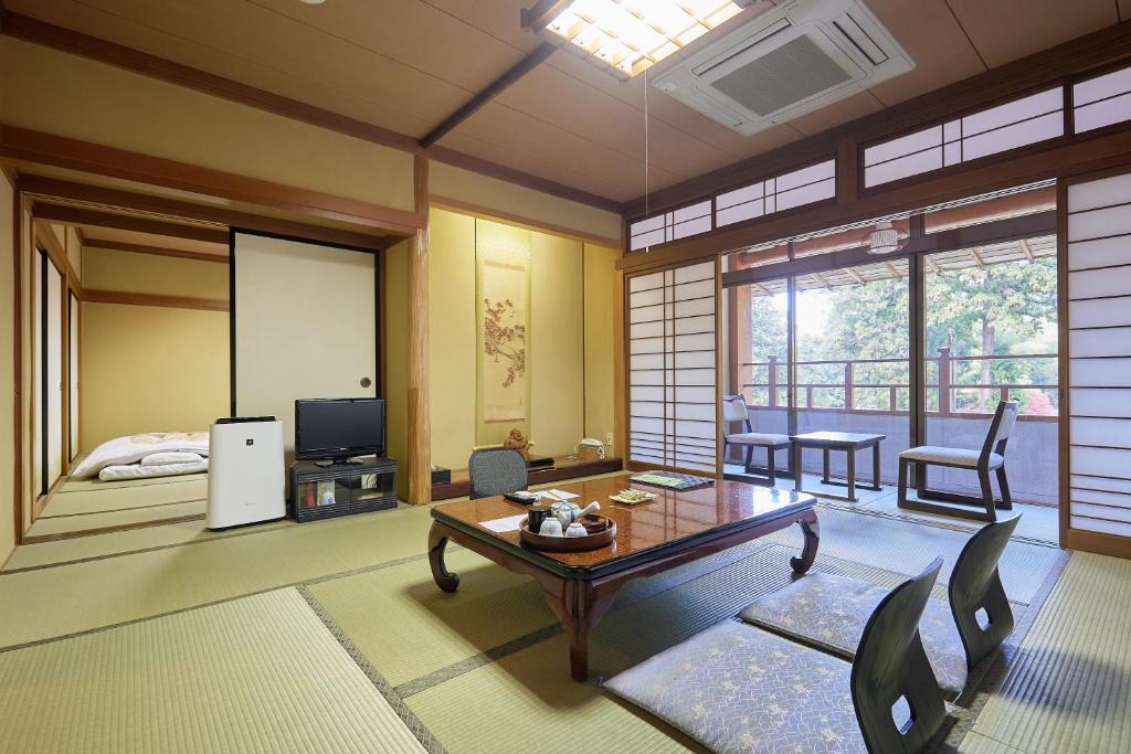 un salon avec un lit et une table dans l'établissement Ryokan Koyokan, à Yasugi