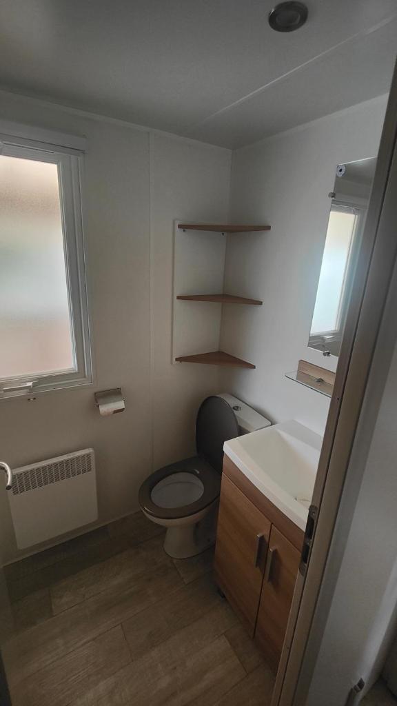 une salle de bain avec toilettes et lavabo dans l'établissement Mobile-Home 6-8 personnes - camping " Les sables du midi", à Valras-Plage 10 autres photos