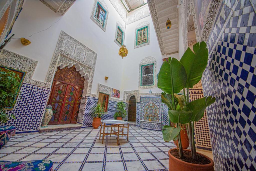 Cette chambre est dotée de carrelage, d'une table et d'une plante. dans l'établissement Riad Rayhane Fes, à Fès
