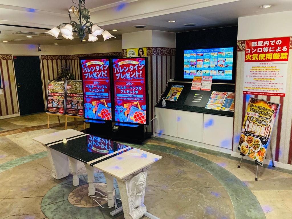 - une salle de jeux avec une table et des jeux vidéo dans l'établissement ホテル パレドフルー, à Toyonaka