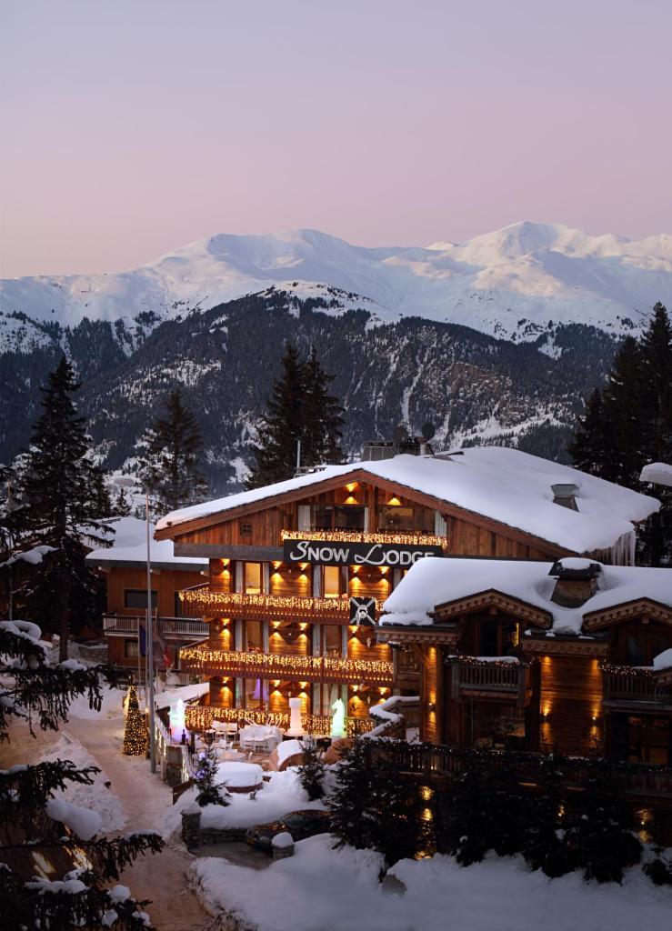 un lodge de ski avec des montagnes enneigées en arrière-plan dans l'établissement Snow Lodge Hotel Courchevel 1850, à Courchevel