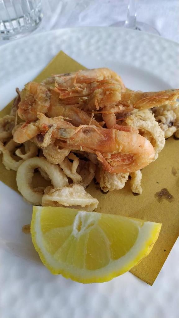 une plaque de nourriture avec des crevettes et une tranche de chaux dans l'établissement Residence Parco del Sole, à Rodi Garganico