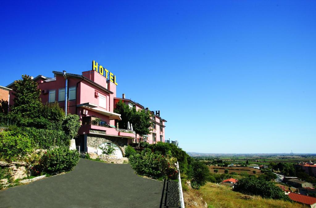 un bâtiment au sommet d'une colline avec un court de tennis dans l'établissement Hotel Tarconte, à Tarquinia