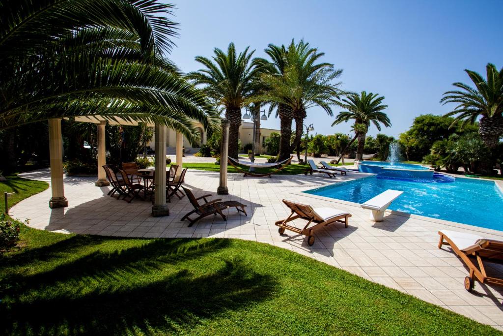 un complexe avec piscine et palmiers dans l'établissement Villa Incoronata, à Nardò