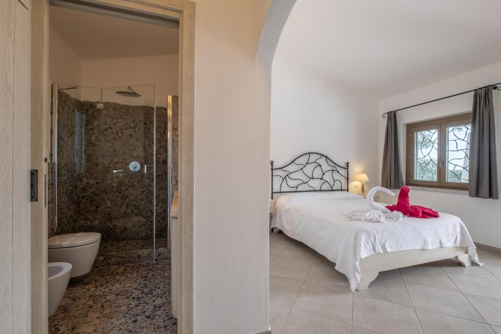 une chambre avec un lit et une salle de bain avec douche dans l'établissement Piscina Privata- Luxury Villa 100m dalla Spiaggia, à Palau