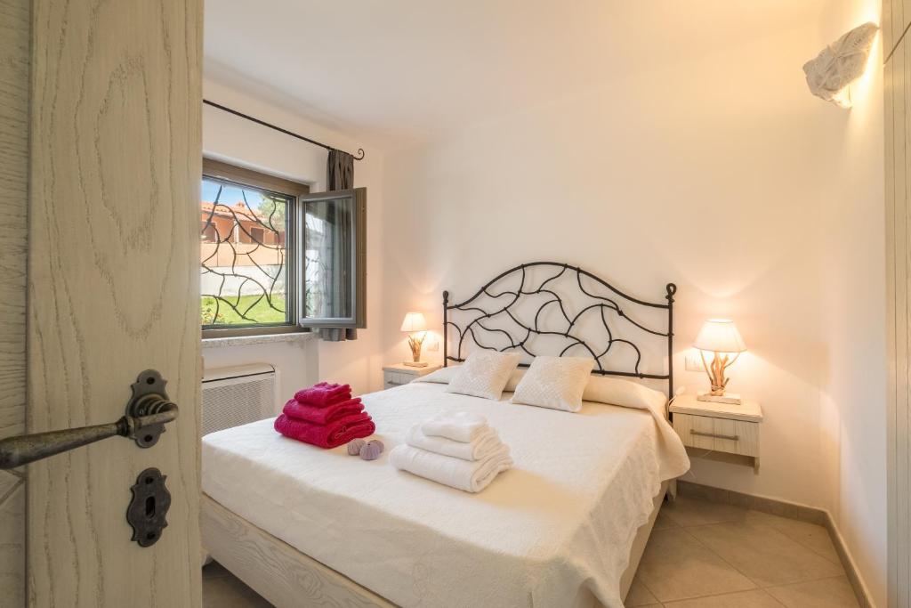 une chambre avec un lit avec des serviettes dessus dans l'établissement Piscina Privata- Luxury Villa 100m dalla Spiaggia, à Palau