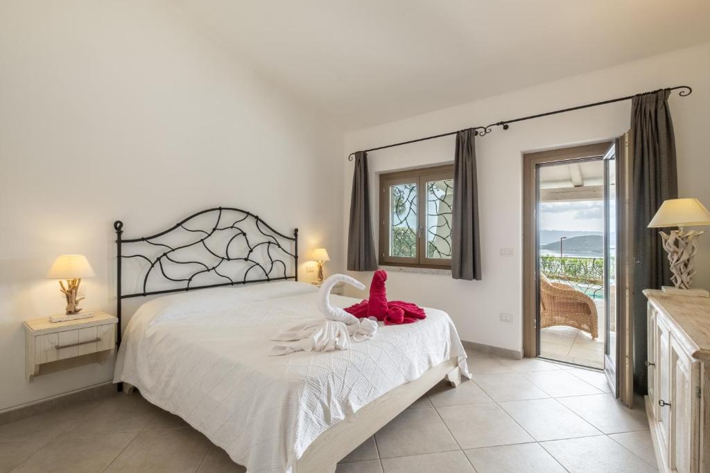 - une chambre avec un lit avec un animal farci rouge dans l'établissement Piscina Privata- Luxury Villa 100m dalla Spiaggia, à Palau 32 autres photos