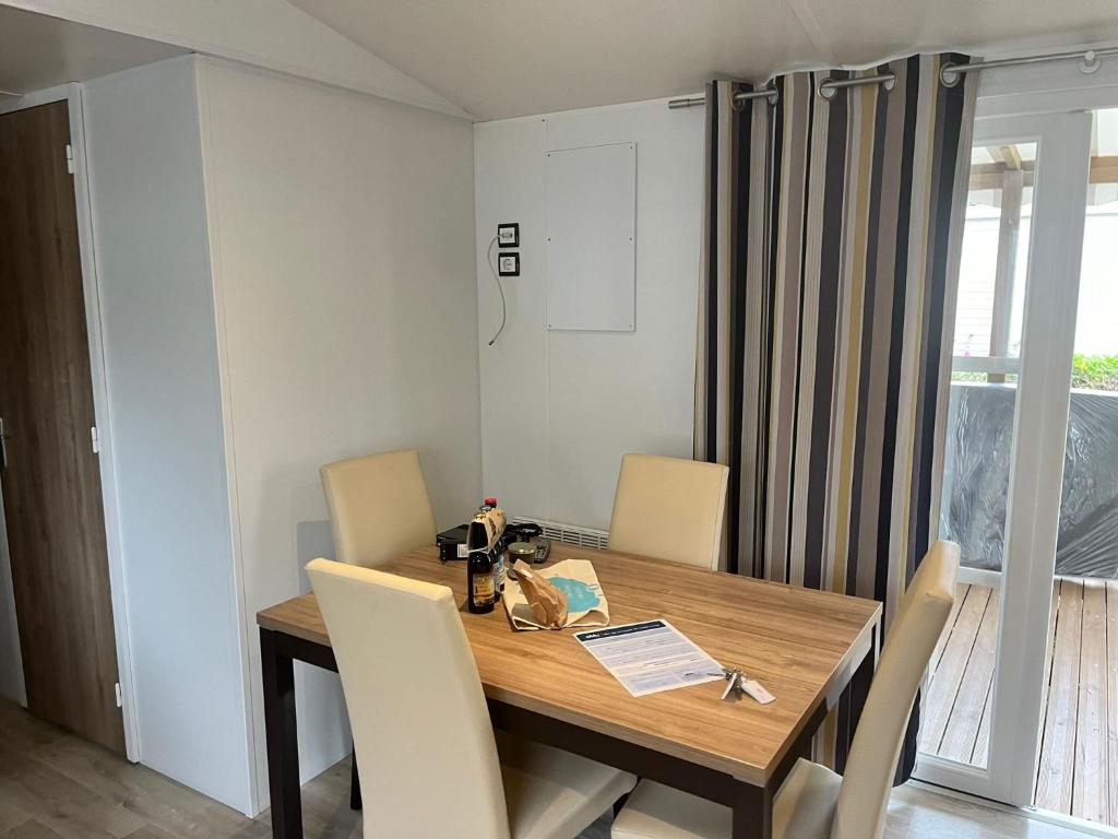 une salle à manger avec une table et des chaises en bois dans l'établissement MH 385 3 chambre ET 1 salle de bain 40M2 dans camping 4 étoiles, à Saint-Julien-en-Born 7 autres photos