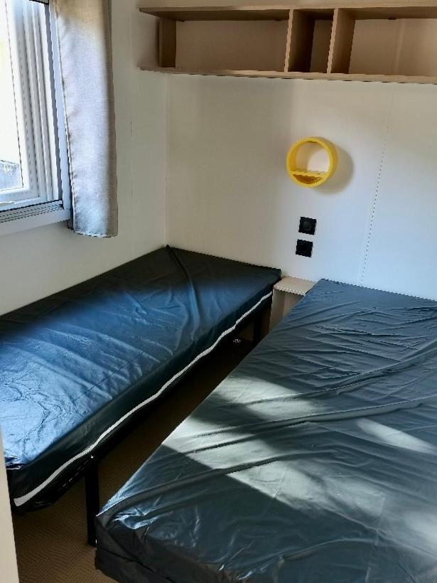 un lit dans une chambre avec une fenêtre dans l'établissement Mobil-home Comfort XL 3 chambres 6 pers, au Grau-du-Roi
