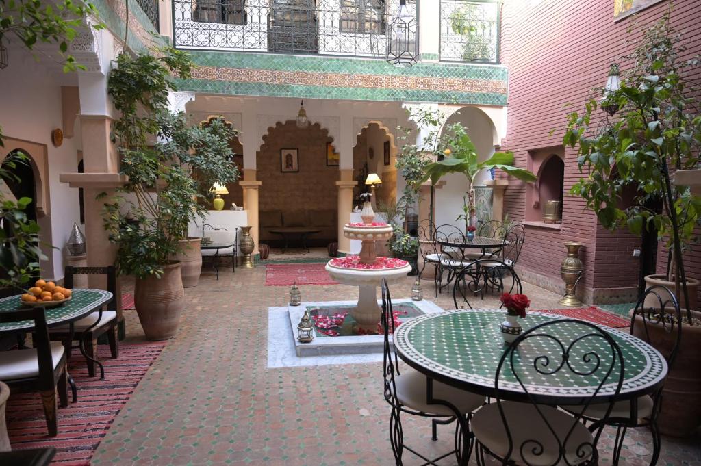 une cour avec des tables et des chaises dans un bâtiment dans l'établissement Riad Errabii & Spa, à Marrakech