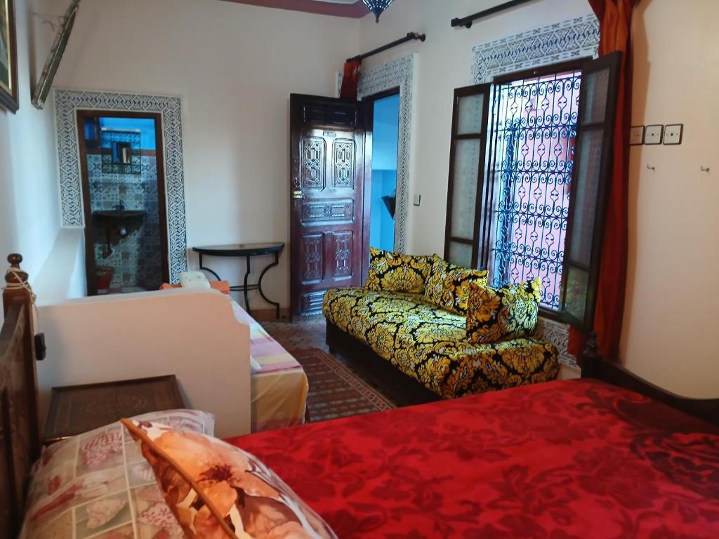 un salon avec un canapé et un lit dans l'établissement Riad Idrissi, à Meknès