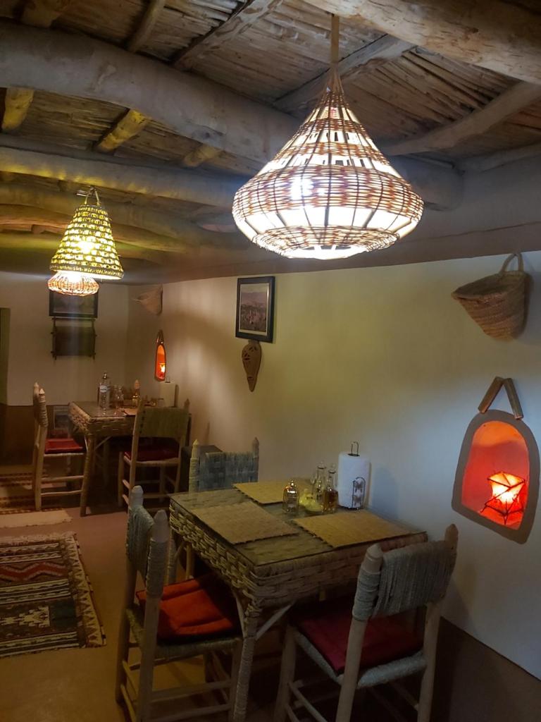 - une salle à manger avec une table, des chaises et des lumières dans l'établissement DAR DANI café restaurant, à Boumalne 37 autres photos