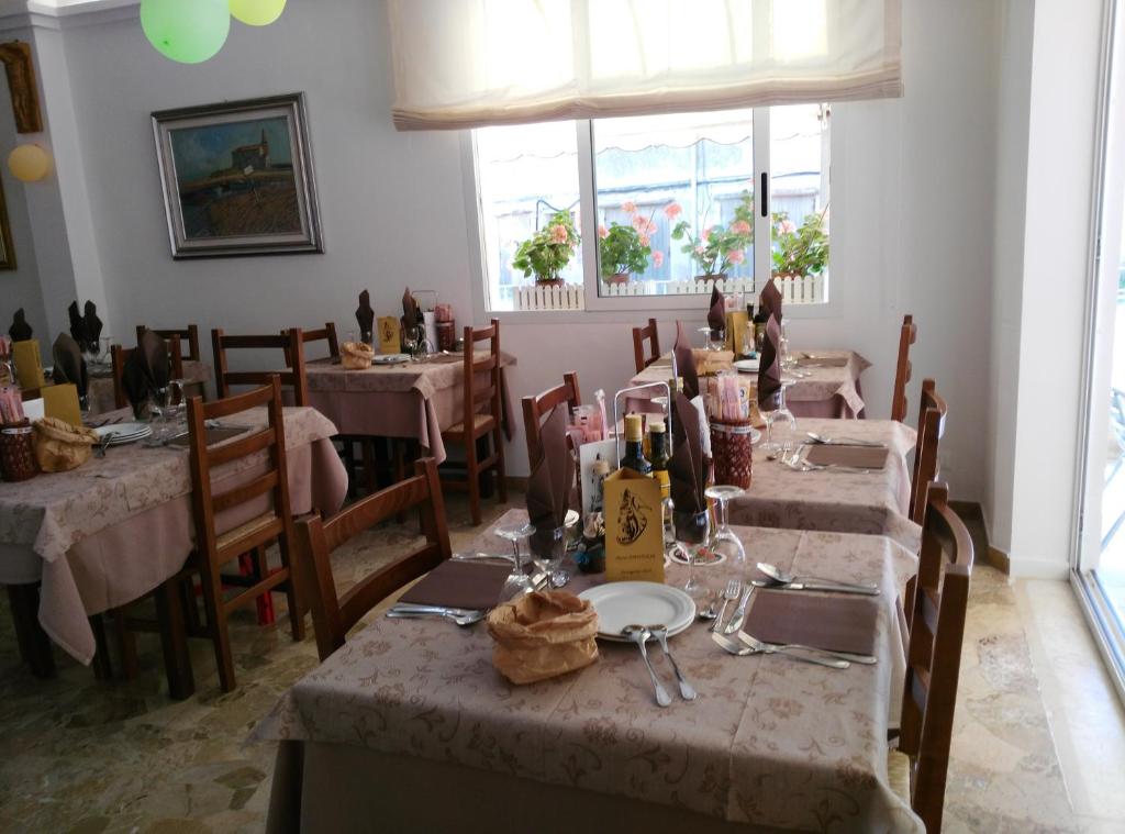 - une salle à manger avec des tables et des bouteilles de vin dans l'établissement Hotel Souvenir, à Caorle