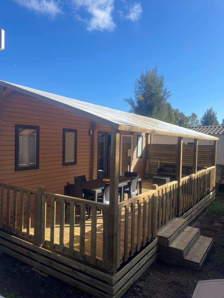 un porche sur une maison avec une terrasse dans l'établissement Mobil-home neuf 6 à 8 pers au Camping Les Palmiers, Hyères, à Hyères