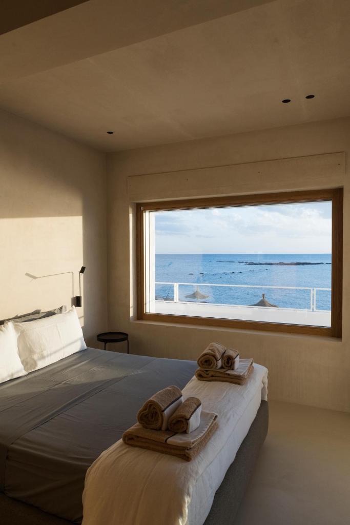 - une chambre avec une grande fenêtre donnant sur l'océan dans l'établissement Calitro Mare, à Torre Ovo