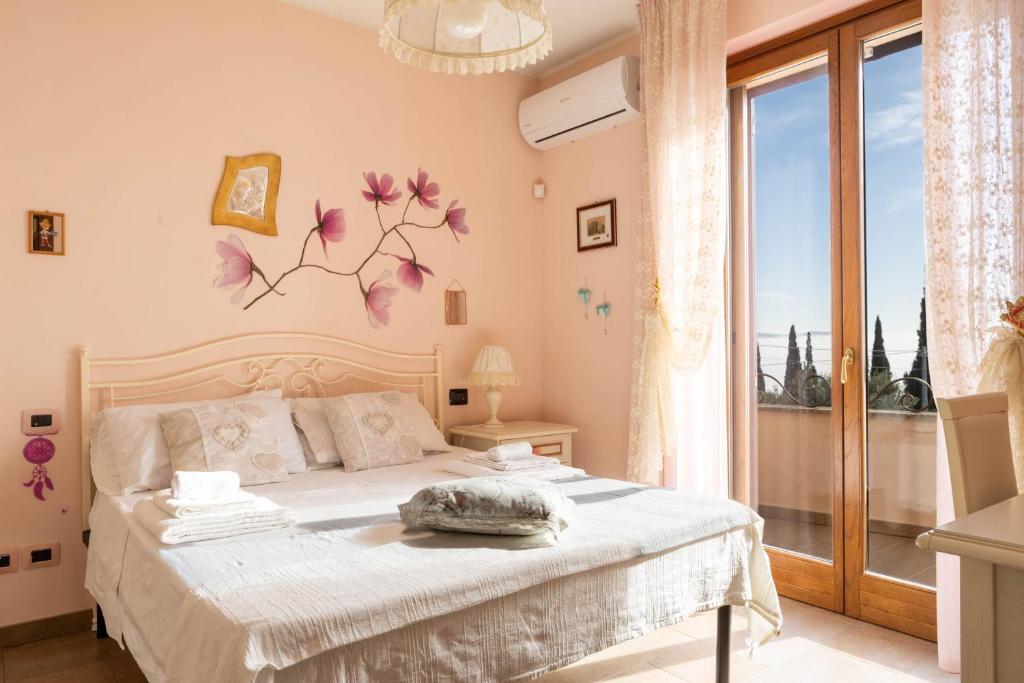 une chambre avec un lit et une grande fenêtre dans l'établissement Villa il Mandorlo by VacaVilla, à Passignano sul Trasimeno