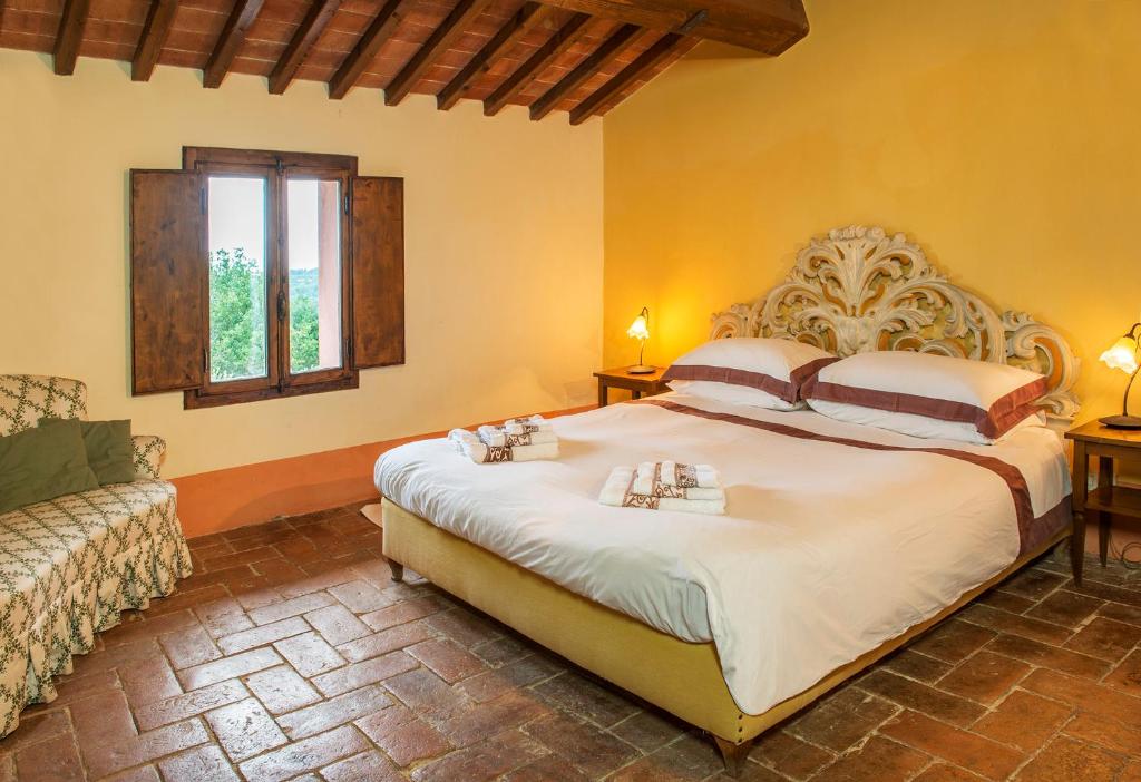 une chambre avec un grand lit et une fenêtre dans l'établissement Villa Belvedere, à Montopoli in Val dʼArno