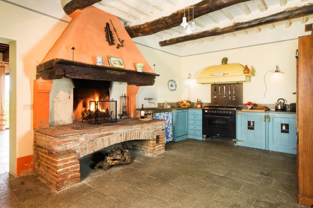 - une cuisine avec un four en briques au milieu dans l'établissement Villa Belvedere, à Montopoli in Val dʼArno