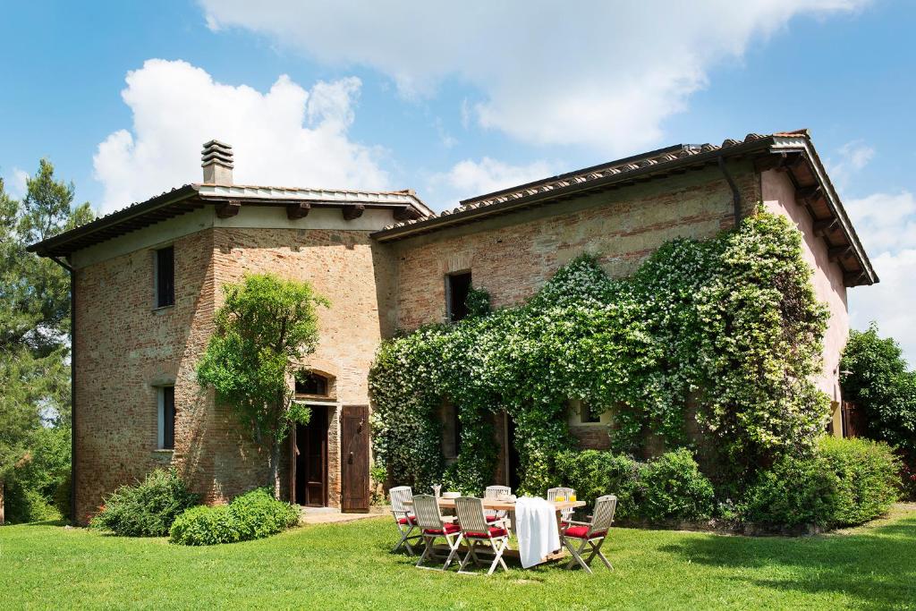 une table et des chaises devant un bâtiment dans l'établissement Villa Belvedere, à Montopoli in Val dʼArno