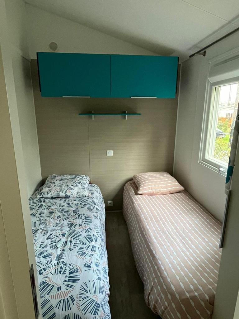 - une petite chambre avec 2 lits et une armoire bleue dans l'établissement Mobilhome Mag Ced les Dunes de contis Piscines et Plage, à Saint-Julien-en-Born 25 autres photos