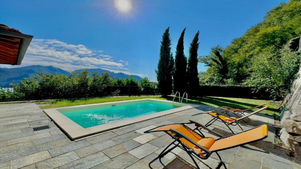 une paire de chaises et une piscine dans l'établissement Villa Serena, à Plesio