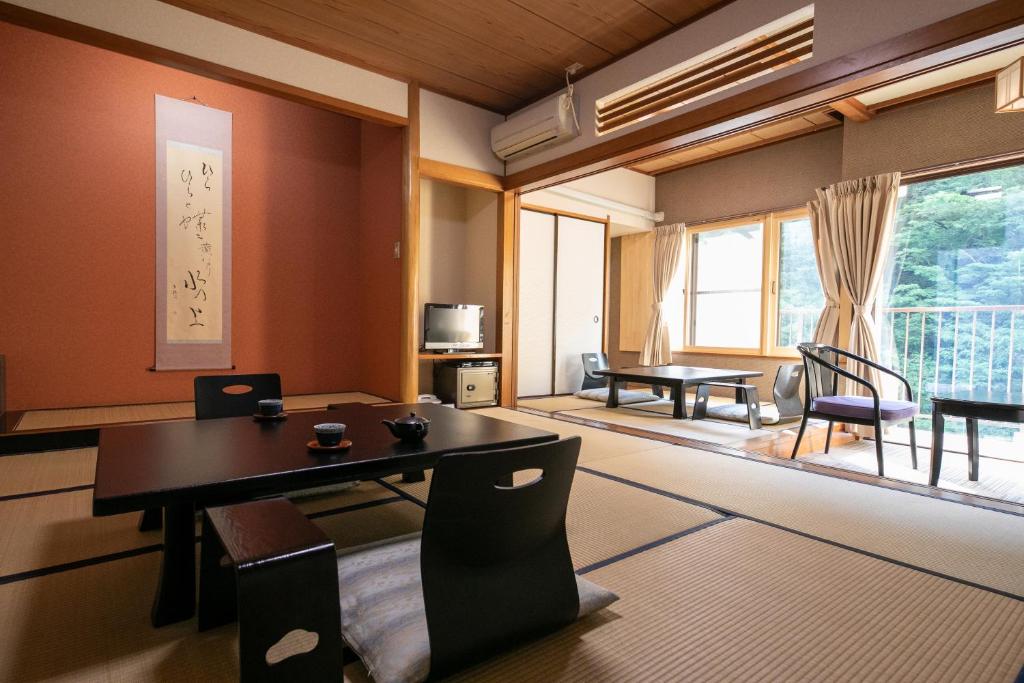 une salle à manger avec une table et des chaises dans une pièce dans l'établissement Shiunso, à Hakone