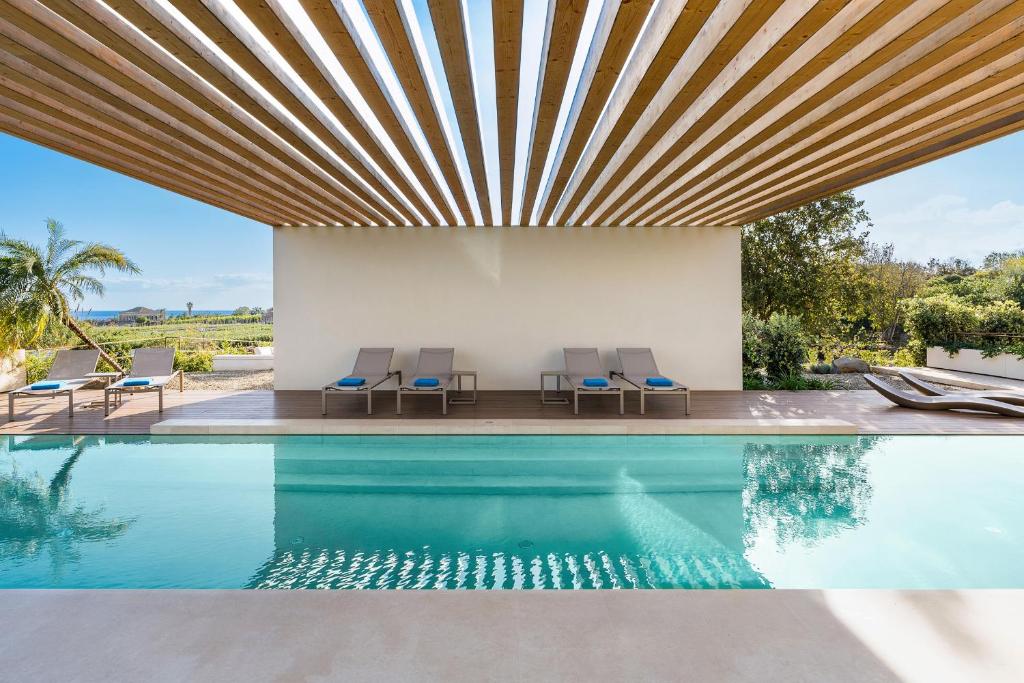 une piscine avec un plafond en bois et des chaises ainsi qu'une maison dans l'établissement Hermosa, à San Leonardello 65 autres photos