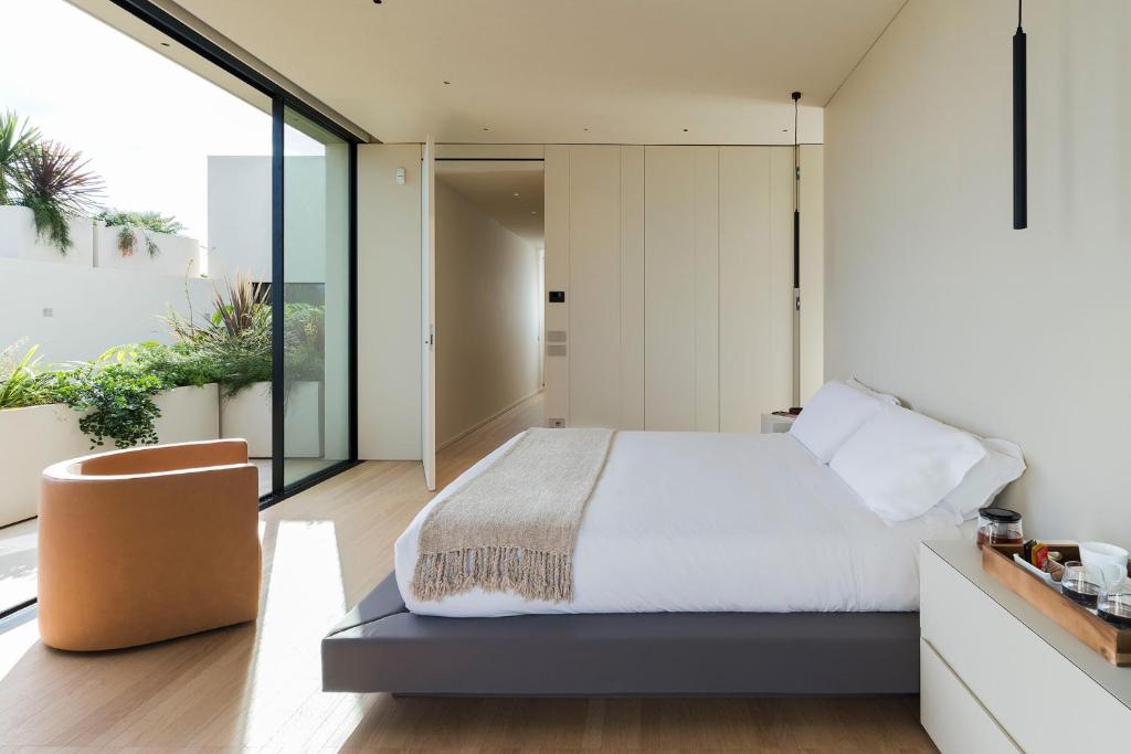 - une chambre avec un grand lit et des parois en verre dans l'établissement Hermosa, à San Leonardello