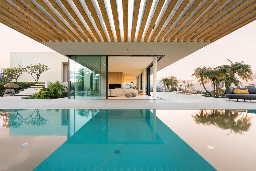 - une piscine dans une maison dotée d'un plafond en bois dans l'établissement Hermosa, à San Leonardello