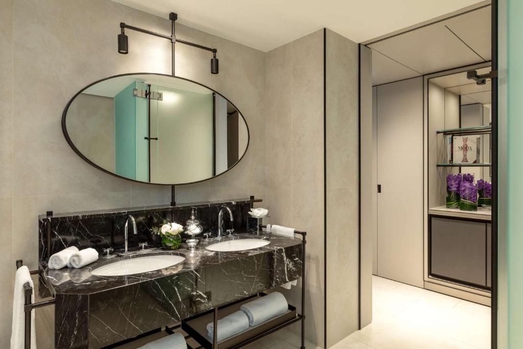 une salle de bain avec deux lavabos et un grand miroir dans l'établissement Tivoli Portopiccolo Sistiana Wellness Resort & Spa, à Sistiana 147 autres photos