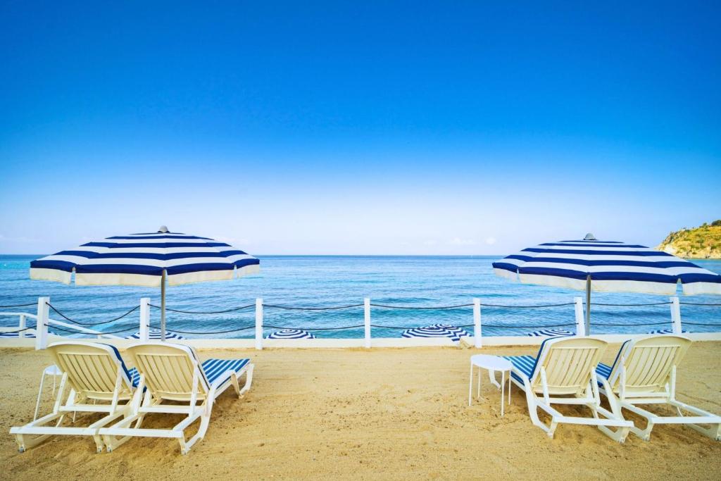 un groupe de chaises et de parasols sur une plage dans l'établissement Hotel Ipomea Club, à Capo Vaticano 52 autres photos