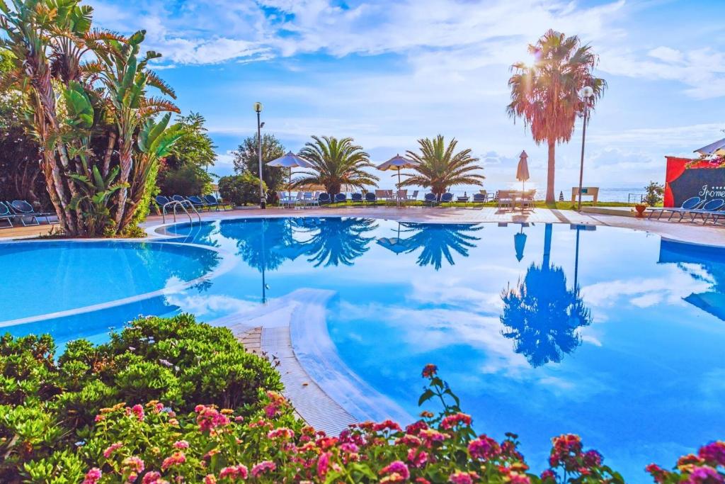 - une piscine bordée de palmiers et de fleurs dans l'établissement Hotel Ipomea Club, à Capo Vaticano